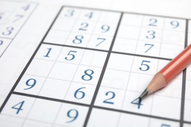 Photo of Sudoku puzzle grid and pencil, closeup view