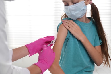 Photo of Doctor vaccinating little girl in hospital. Health care