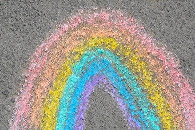Photo of Rainbow drawn with colorful chalks on asphalt outdoors, closeup