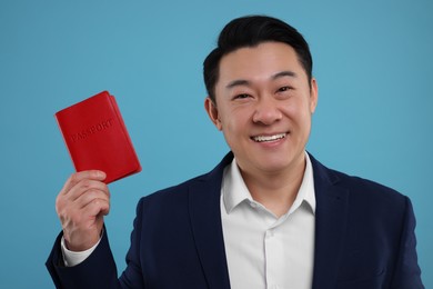 Immigration. Happy man with passport on light blue background