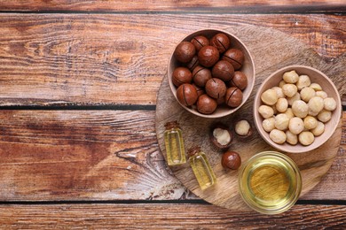 Delicious organic Macadamia nuts and cosmetic oil on wooden table, top view