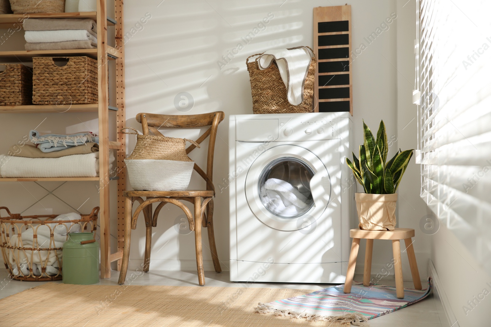 Photo of Modern washing machine in laundry room interior