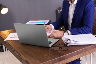 Photo of Businessman working with documents at office table, closeup