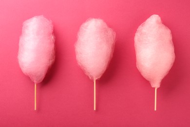 Photo of Sweet cotton candies on pink background, flat lay