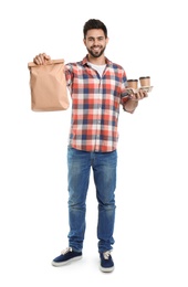 Photo of Young courier with paper bag and drinks on white background. Food delivery service