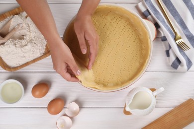Photo of Woman making quiche at white wooden table, top view