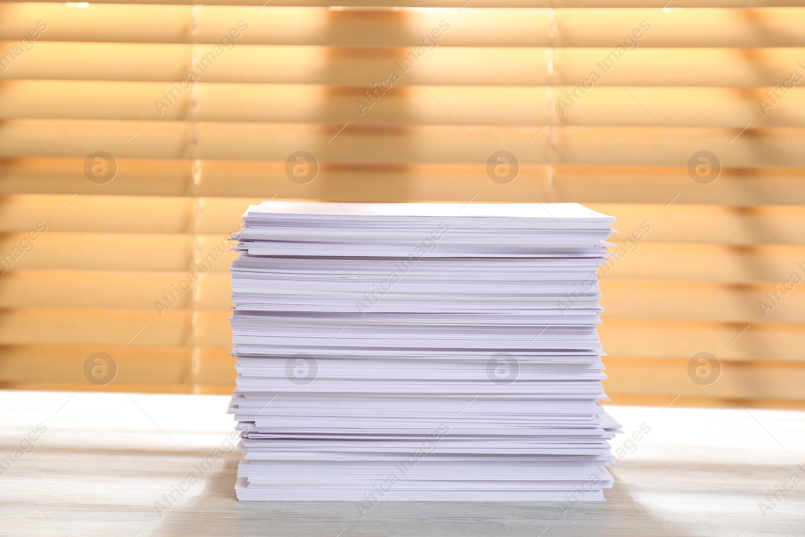 Photo of Stack of paper sheets on white wooden table