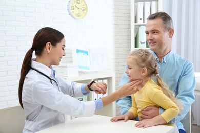 Mature man with granddaughter visiting doctor in hospital. Checking pulse