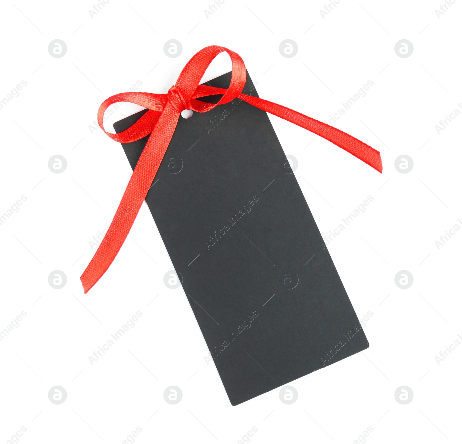 Photo of Blank black gift tag with red satin ribbon on white background, top view. Space for design