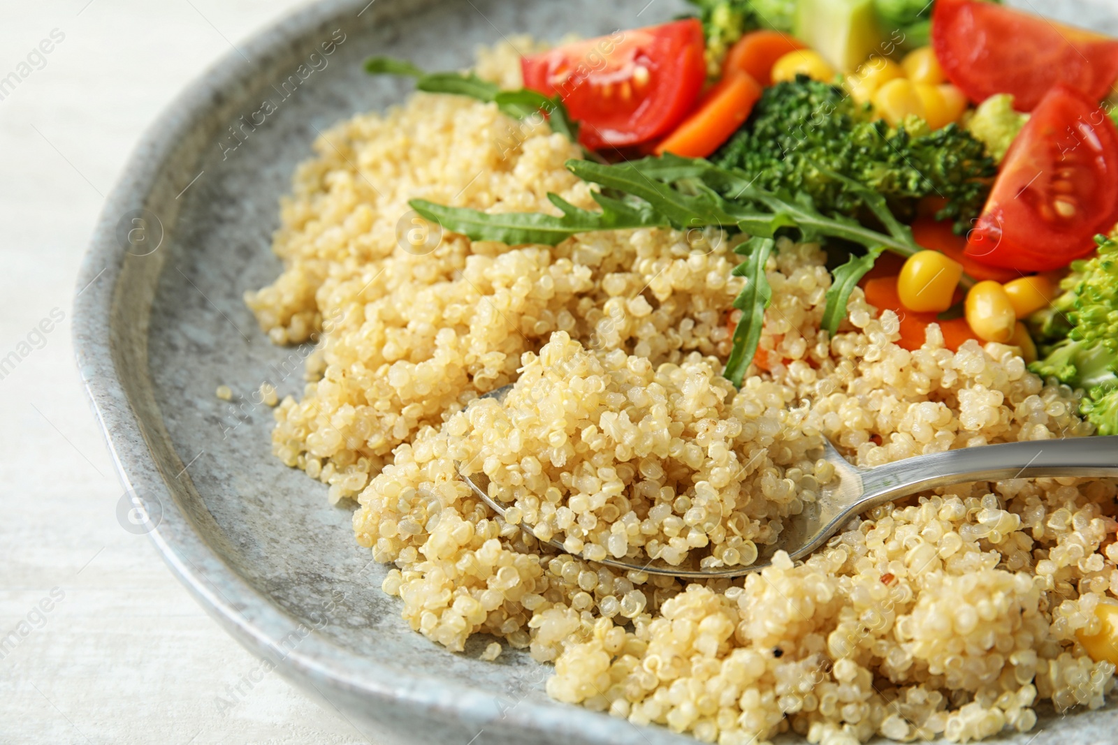 Photo of Plate with quinoa and different vegetables on table, closeup