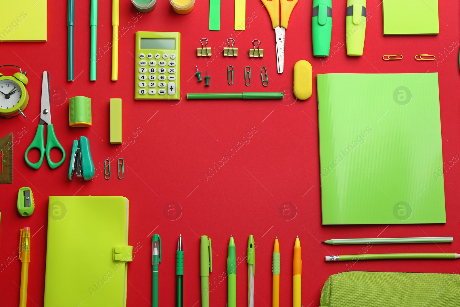 Photo of Frame made with colorful school stationery on red background, flat lay