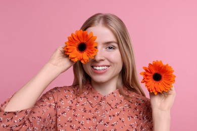 Photo of Beautiful woman with spring flowers in hands on pink background