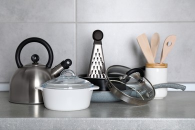 Photo of Set of cooking utensils and cookware on grey countertop