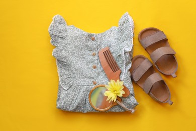Photo of Stylish child clothes, shoes and accessories on yellow background, flat lay