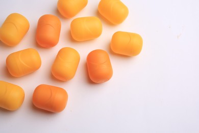 Photo of Sveti Vlas, Bulgaria - June 30, , 2023: Orange plastic capsules from Kinder Surprise Eggs on white background, above view and space for text
