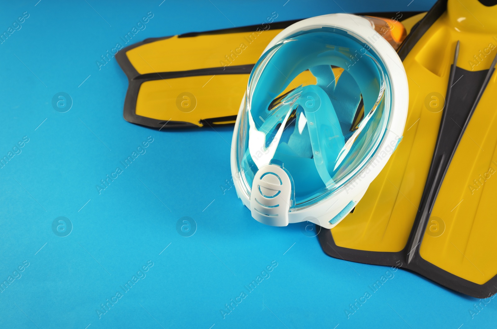 Photo of Pair of yellow flippers and diving mask on color background. Space for text