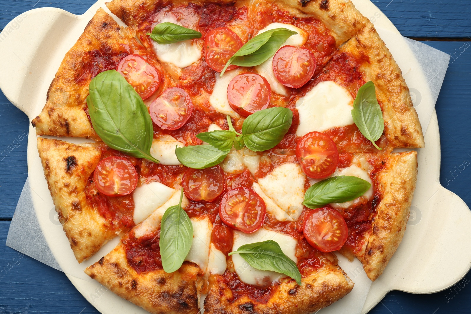 Photo of Delicious Margherita pizza on blue wooden table, top view