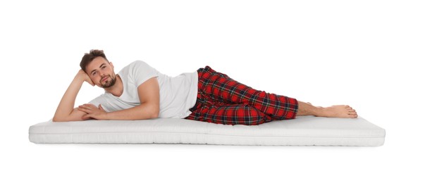 Photo of Man lying on soft mattress against white background
