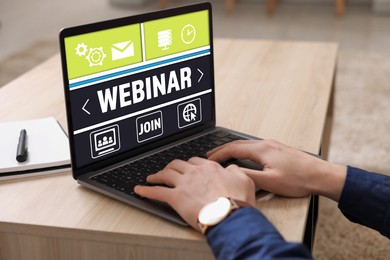 Image of Online webinar, web page on computer screen. Man using laptop at wooden table, closeup