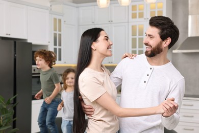Photo of Happy family having fun at home. Couple dancing while children jumping