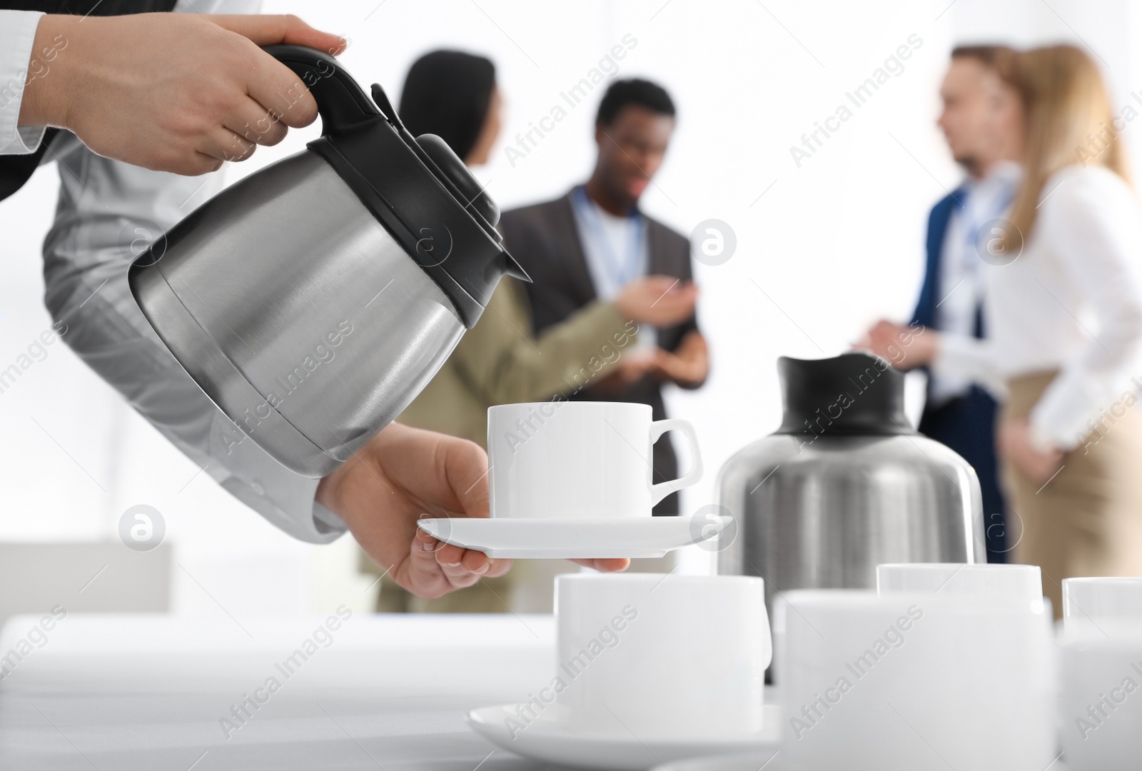 Photo of Waitress pouring hot drink during coffee break, closeup