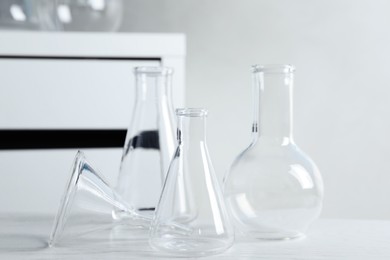 Photo of Set of laboratory glassware on white table indoors