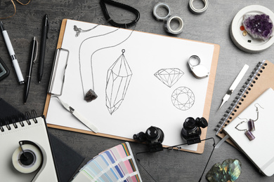 Flat lay composition with drawing of jewelry on grey table. Designer's workplace