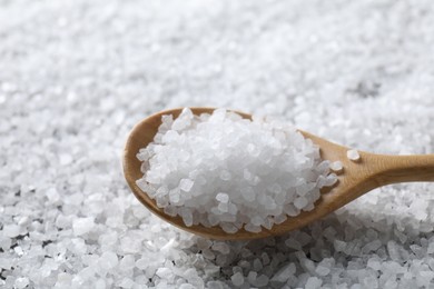 Photo of Natural salt and wooden spoon, closeup view