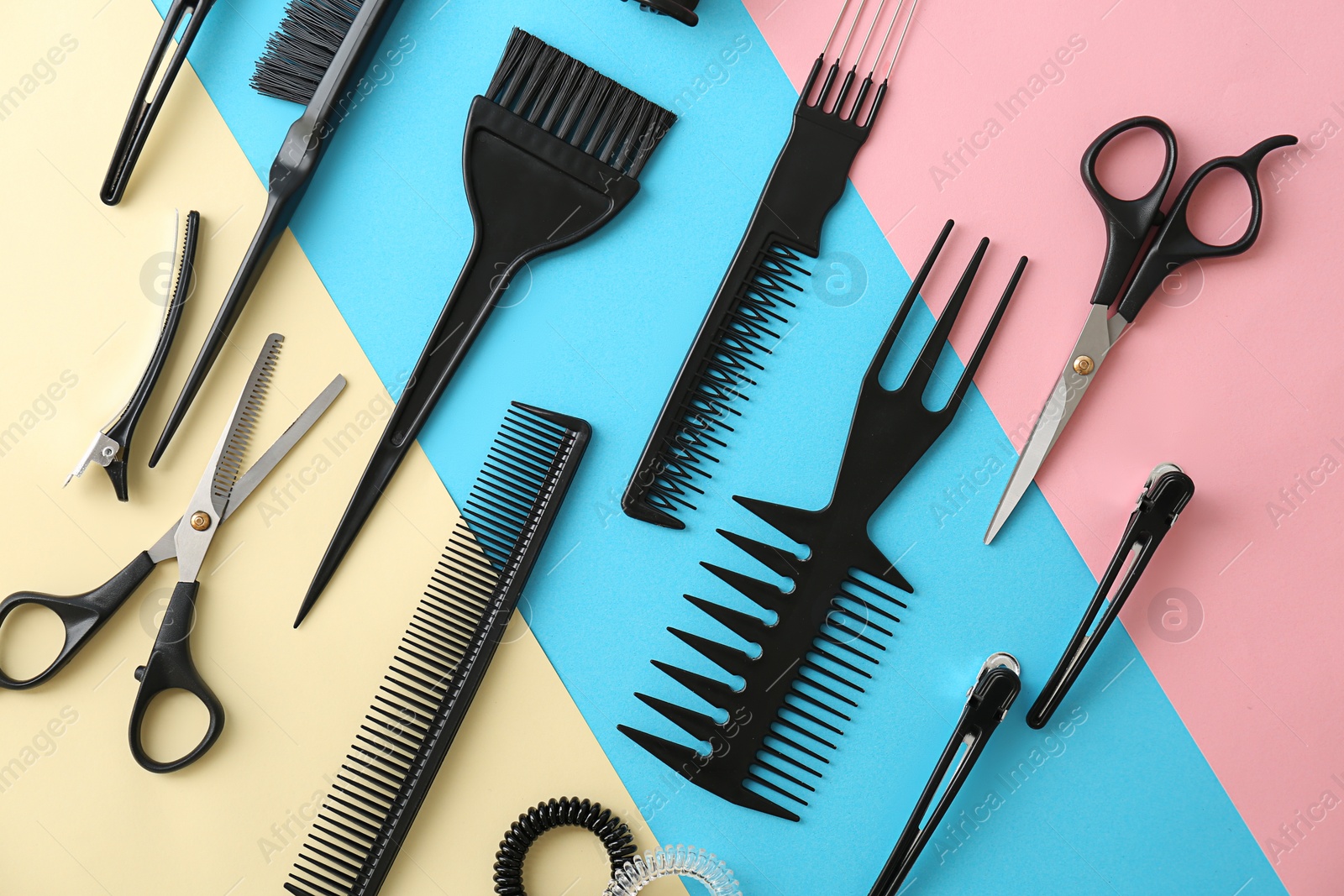 Photo of Flat lay composition with professional hairdresser tools on color background