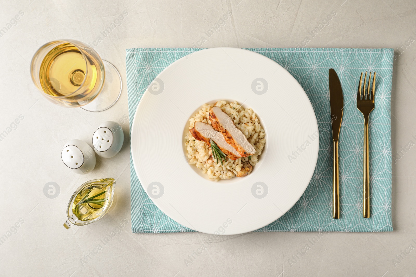 Photo of Delicious chicken risotto served on light grey table, flat lay