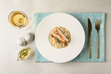 Delicious chicken risotto served on light grey table, flat lay