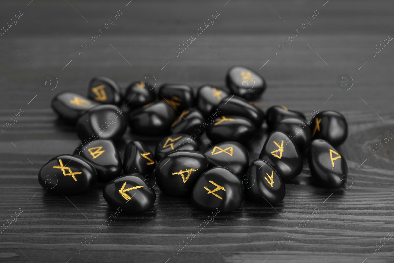 Photo of Pile of rune stones on black wooden table