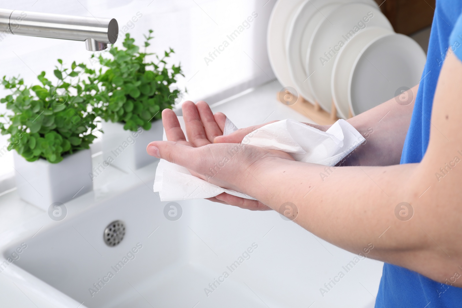 Photo of Man wiping hands with paper towel near sink, closeup