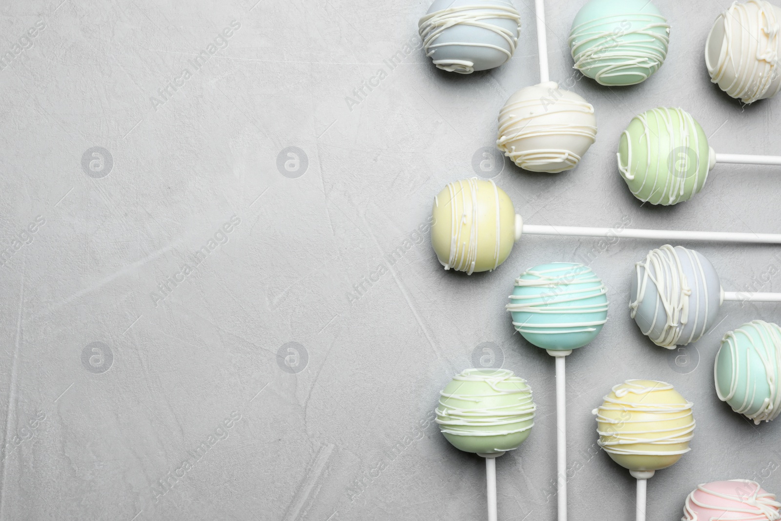 Photo of Sweet cake pops on light grey background, flat lay. Space for text