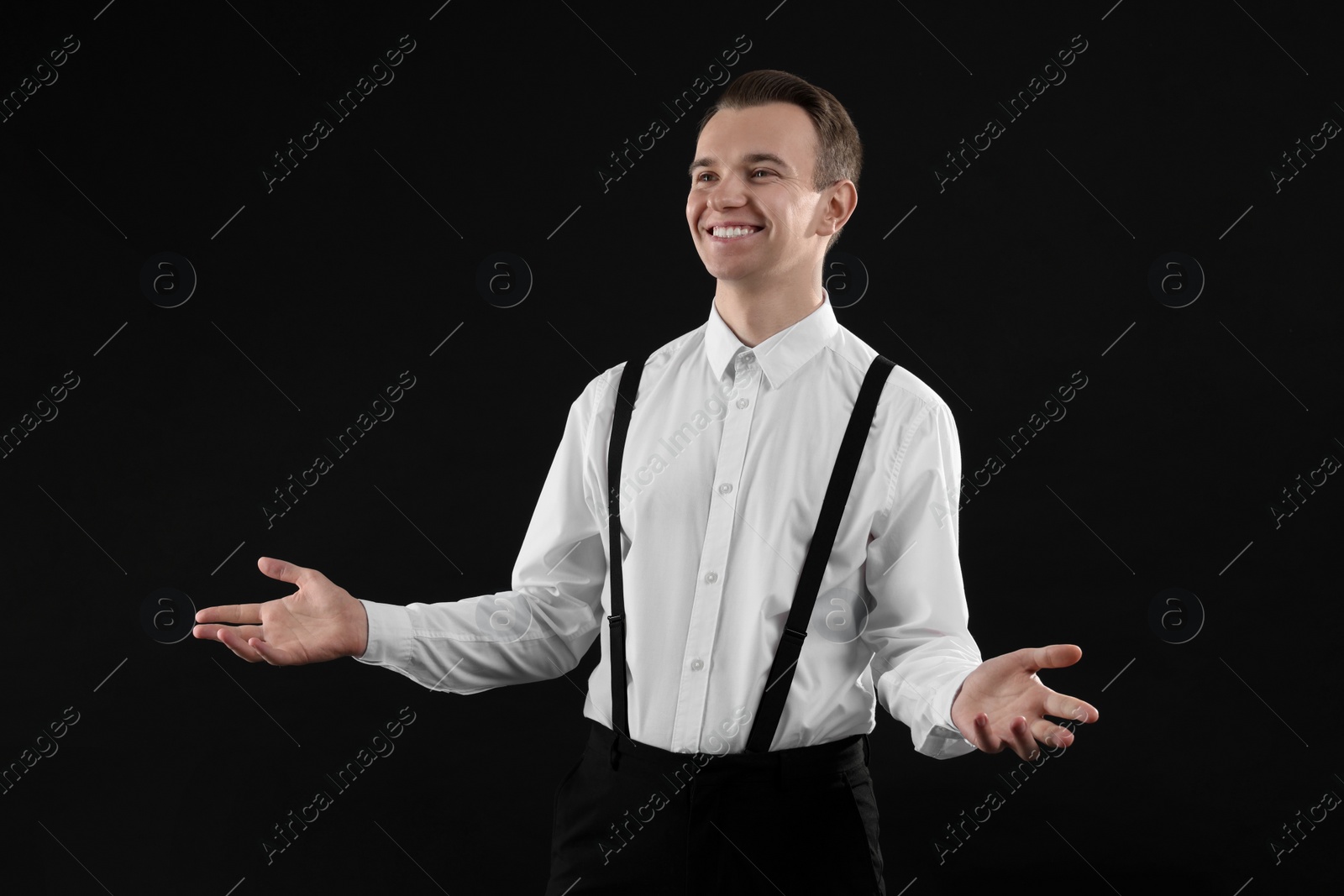 Photo of Handsome young man in white shirt on black background