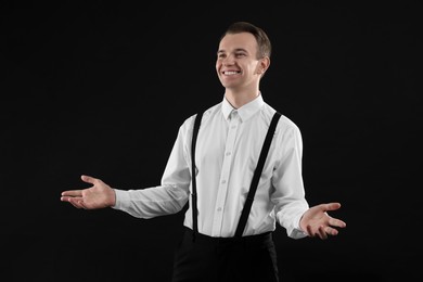 Handsome young man in white shirt on black background