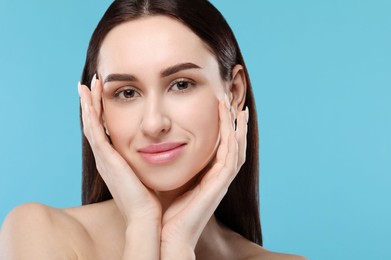 Photo of Portrait of beautiful young woman on light blue background. Space for text