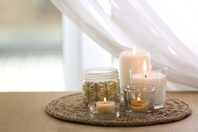 Photo of Beautiful burning candles on table at home