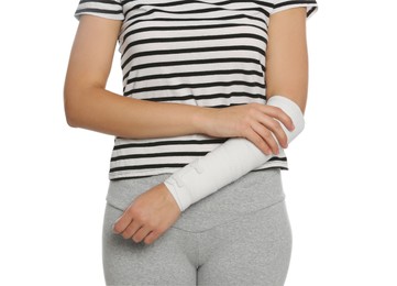 Young woman with arm wrapped in medical bandage on white background, closeup