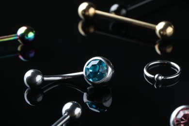 Photo of Stylish jewelry for piercing on black background, closeup