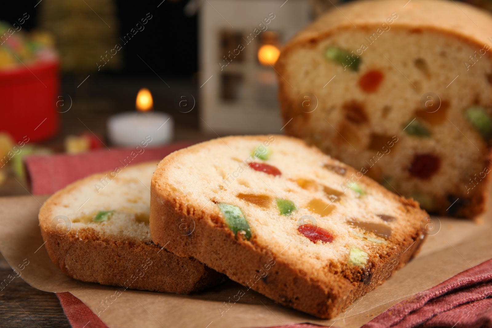 Photo of Delicious cake with candied fruits and Christmas decor on table, closeup