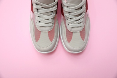 Photo of Pair of stylish women's sneakers on pink background, top view