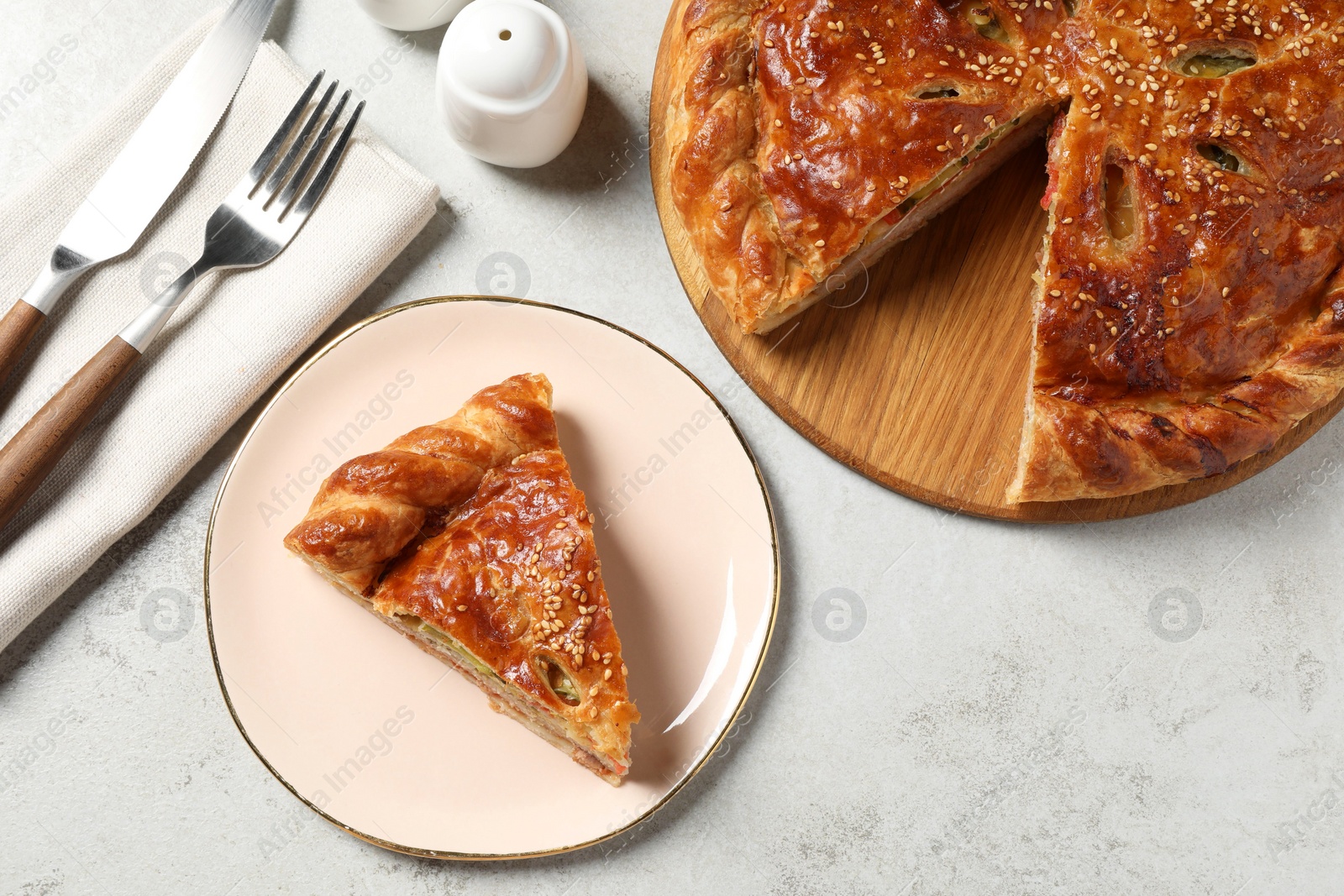 Photo of Tasty homemade pie served on light grey table, flat lay