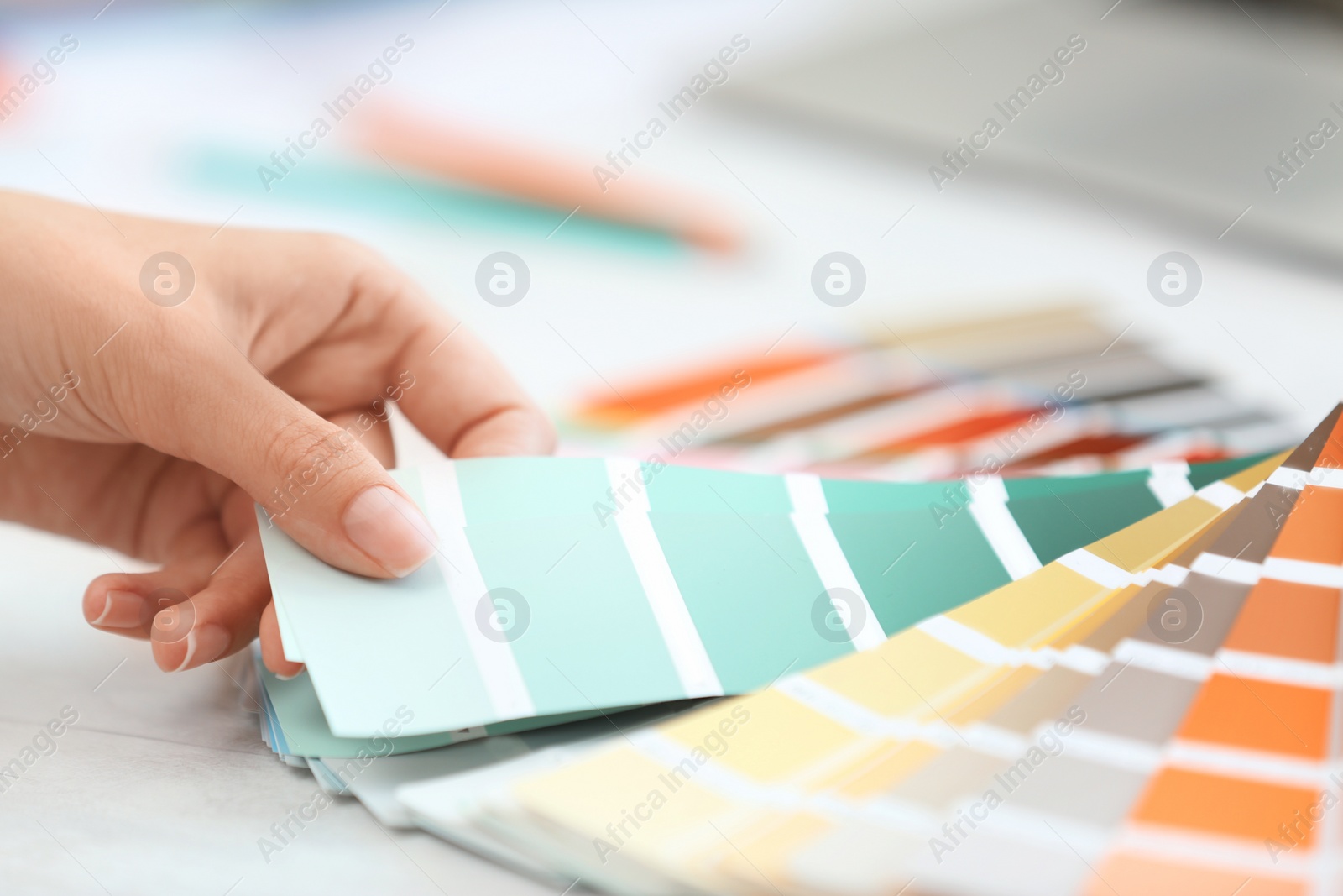 Photo of Woman with paint color palette samples at table, closeup