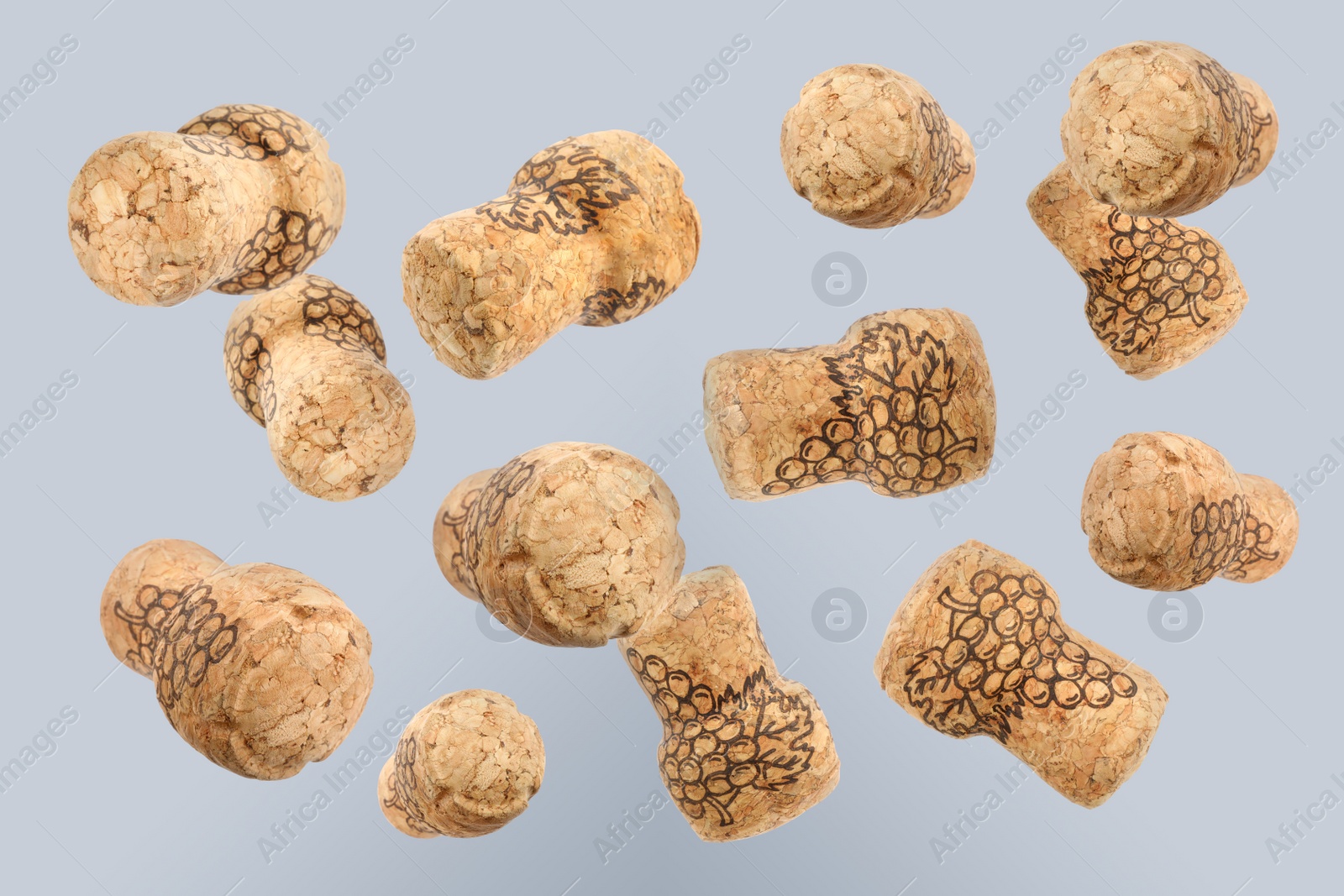 Image of Many corks of sparkling wine bottles falling on light background