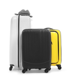 Photo of New suitcases and hat packed for journey on white background