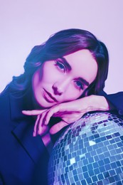 Image of Portrait of beautiful woman with disco ball in neon lights