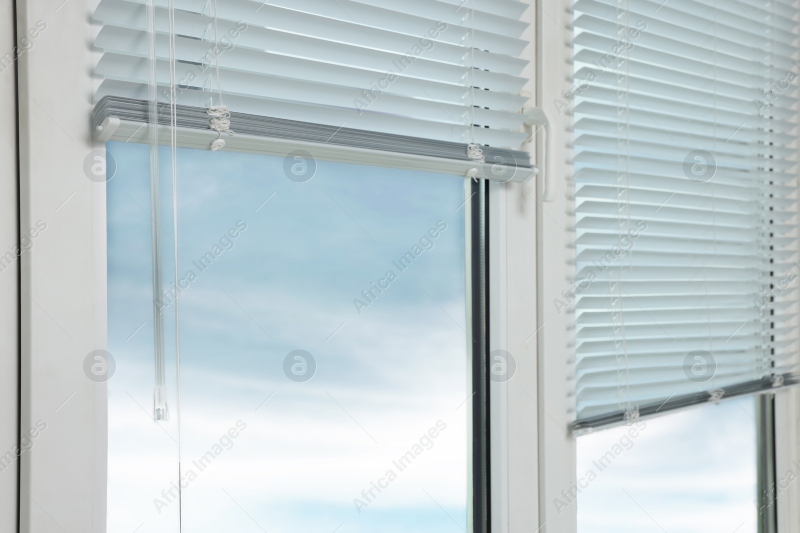 Photo of Stylish window with horizontal blinds in room