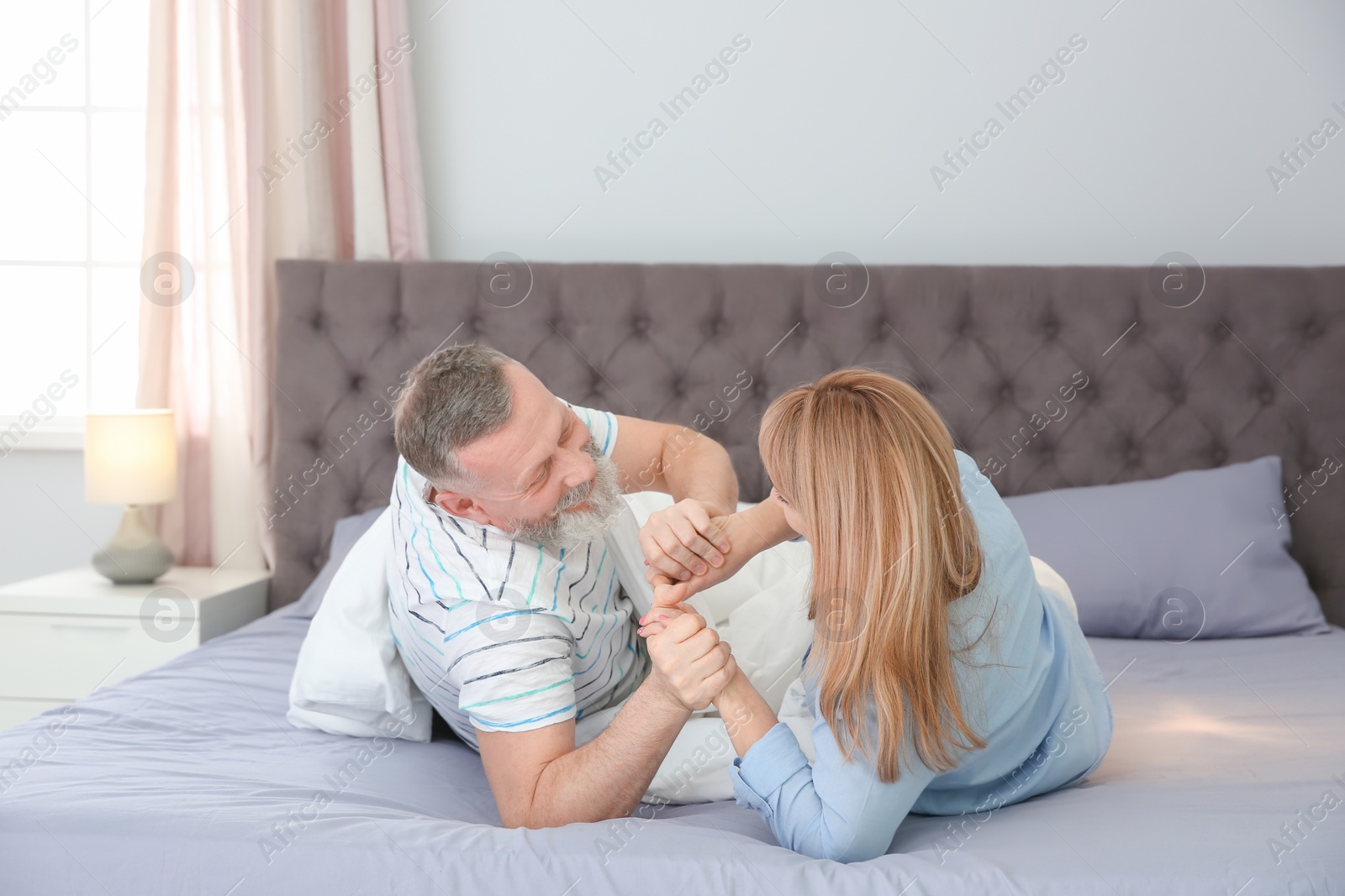 Photo of Mature couple having fun together on bed at home