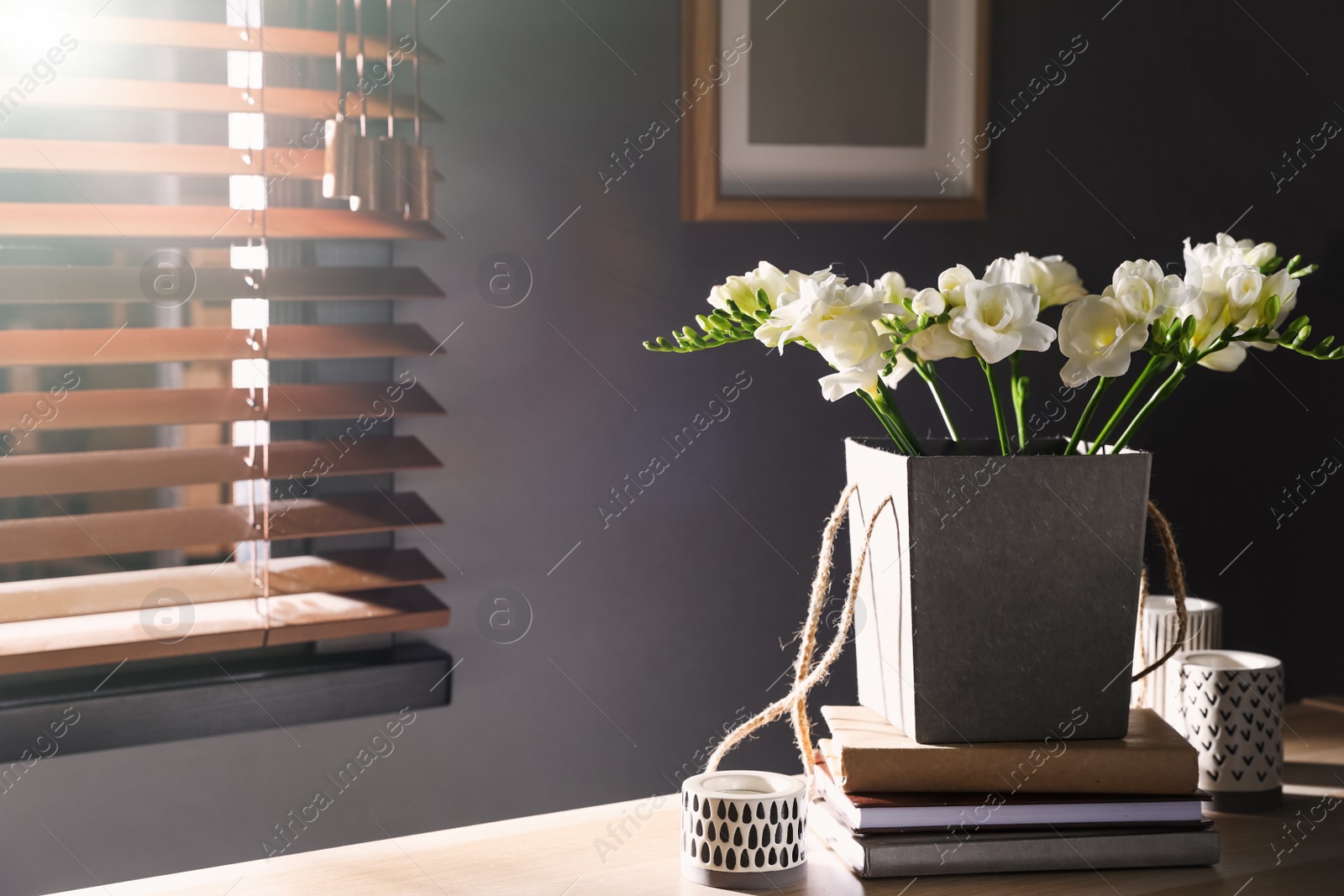 Photo of Beautiful bouquet with spring freesia flowers on wooden table indoors. Space for text